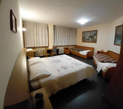 a hotel room with two beds and a couch at Appartamento IN CENTRO a Predazzo in Predazzo