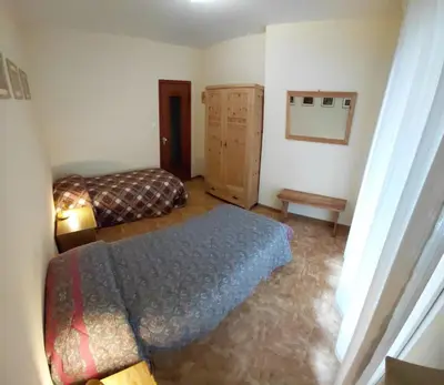 a bedroom with a bed and a dresser in it at Appartamento IN CENTRO a Predazzo in Predazzo