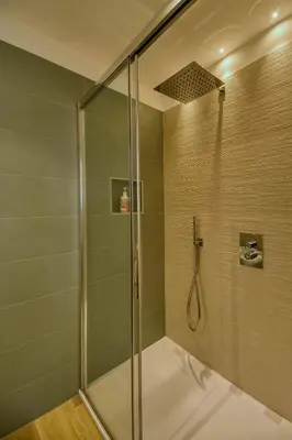 a shower with a glass door in a bathroom at La Corte Delle Dolomiti in Agordo