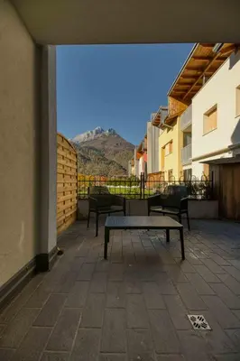 a bench on a balcony with a view of a mountain at La Corte Delle Dolomiti in Agordo