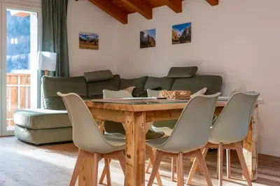 a living room with a wooden table and chairs at Hapina Dolomiti with Garage in Cencenighe