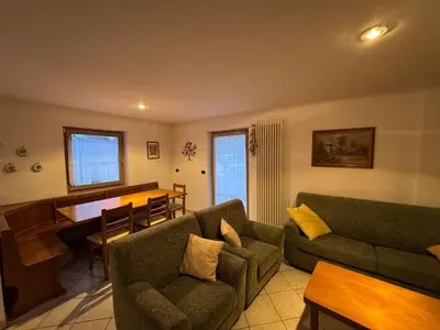 a living room with a couch and a piano at Appartamento Fontane in Panchia