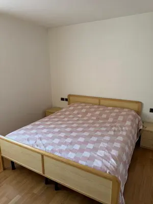 a small bedroom with a bed with a plaid mattress at Appartamento Fontane in Panchia
