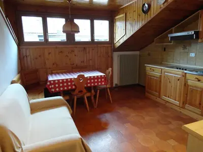 a kitchen with a table and chairs in a room at Appartamento Ciamp in Pozza di Fassa