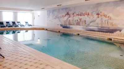 a large swimming pool with a painting on the wall at Grifone Dolomiti Resort in Arabba