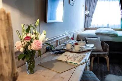 a room with a table with a vase of flowers at Grifone Dolomiti Resort in Arabba
