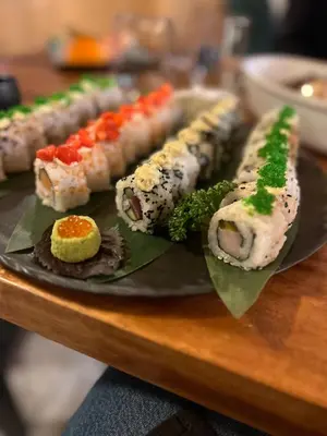 a plate of sushi on a wooden table at Grifone Dolomiti Resort in Arabba