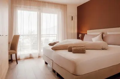 a bedroom with a large bed and a large window at Kronsun Percha in Perca