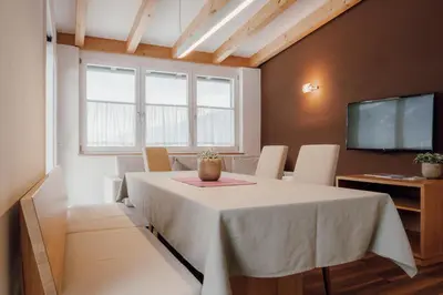 a dining room with a white table and a tv at Kronsun Percha in Perca