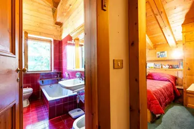 a bathroom with a sink and a bed and a tub at Villa Allegra 2 Tofane monuntains view in Cortina dʼAmpezzo