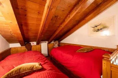 two red beds in a room with wooden ceilings at Villa Allegra 2 Tofane monuntains view in Cortina dʼAmpezzo