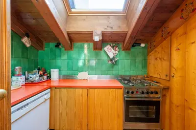a kitchen with wooden cabinets and a red counter top at Villa Allegra 2 Tofane monuntains view in Cortina dʼAmpezzo