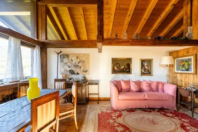 a living room with a pink couch and a table at Villa Allegra 2 Tofane monuntains view in Cortina dʼAmpezzo