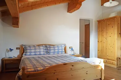 a bedroom with a wooden bed in a room with wooden ceilings at La Sloda in Forno di Zoldo