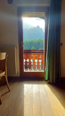 a room with bunk beds and a table and a mirror at La Sloda in Forno di Zoldo