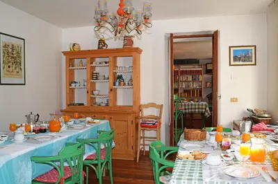 a bedroom with a bed and a desk and a window at La Sloda in Forno di Zoldo