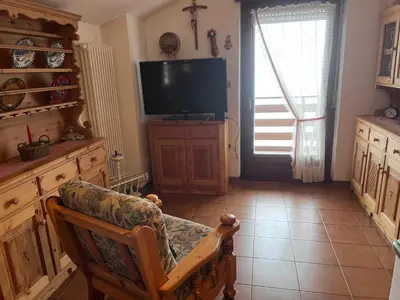 a living room with a tv and a couch and a chair at Il Rifugio del Brunone in Valda
