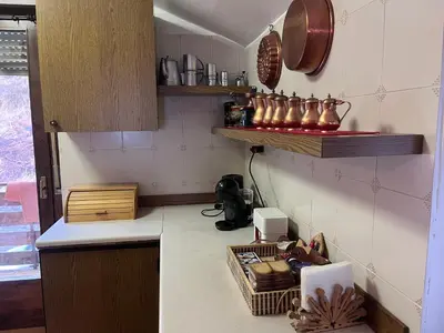 a kitchen with a counter and shelves on the wall at Il Rifugio del Brunone in Valda