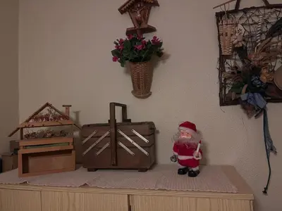 a santa claus figurine on top of a dresser with a cross at Il Rifugio del Brunone in Valda