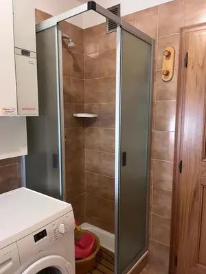a shower in a bathroom with a washing machine at Il Rifugio del Brunone in Valda