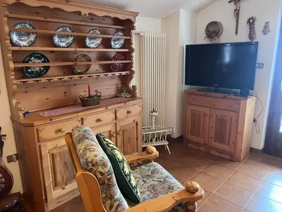 a living room with a couch and a television at Il Rifugio del Brunone in Valda