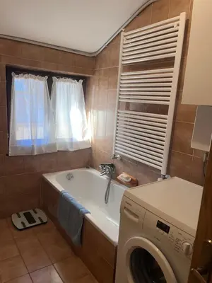 a bathroom with a tub and a washing machine at Il Rifugio del Brunone in Valda