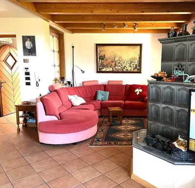 a living room with a red couch and a fireplace at Villa Grumes by Sunhome Fiemme in Grumes
