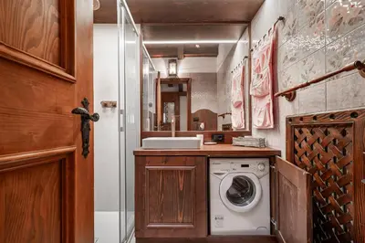 a laundry room with a washing machine in it at GuestHost - Cortina Charming Wooden Alpine Nest in Cortina dʼAmpezzo