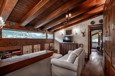 a living room with two couches and a television at GuestHost - Cortina Charming Wooden Alpine Nest in Cortina dʼAmpezzo