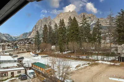 a view of a town with mountains in the background at GuestHost - Cortina Charming Wooden Alpine Nest in Cortina dʼAmpezzo