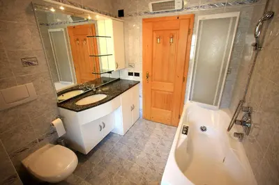 a bathroom with a tub and a sink and a toilet at Cesa Bernard - Apartment Cima 12 e new Apartment Fraine in Pozza di Fassa