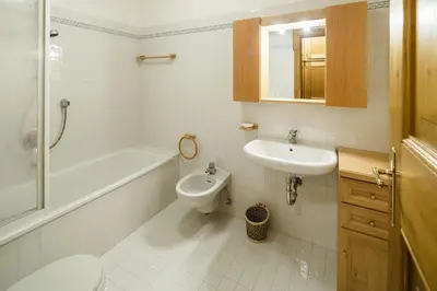 a bathroom with a sink and a toilet and a bath tub at Villa Lacedel - Stayincortina in Cortina dʼAmpezzo