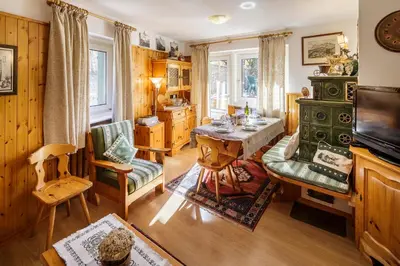 a living room with a table and chairs and a television at CiasaToa in Cortina dʼAmpezzo