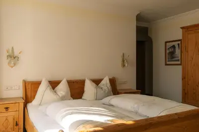 a bedroom with a bed with white sheets and pillows at Hotel Roduna in Rodengo