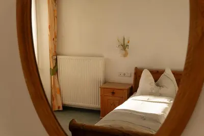 a small bedroom with a bed and a night stand at Hotel Roduna in Rodengo
