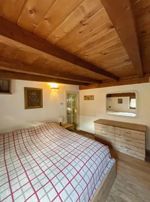 a bedroom with a large bed and a wooden ceiling at Casa Vacanze Carano - El Me Tabià in Carano