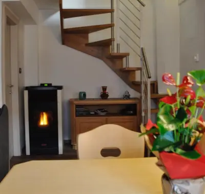 a dining room with a table and a fireplace at Casa Vacanze Carano - El Me Tabià in Carano