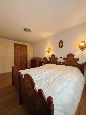 a bedroom with a large bed and a clock on the wall at Casa Vacanze Carano - El Me Tabià in Carano