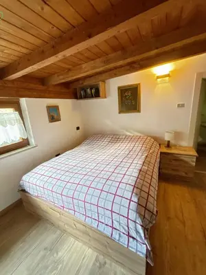 a bedroom with a bed in a room with wooden ceilings at Casa Vacanze Carano - El Me Tabià in Carano