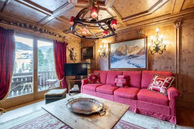 a living room with a red couch and a table at Apartment Tiarè by My Villa Collection in Cortina dʼAmpezzo