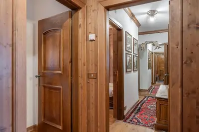 a hallway with wooden doors and a rug at Apartment Tiarè by My Villa Collection in Cortina dʼAmpezzo