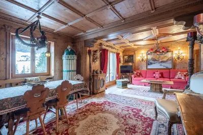a living room with a pink couch and a table at Apartment Tiarè by My Villa Collection in Cortina dʼAmpezzo