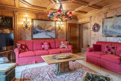 a living room with red couches and a table at Apartment Tiarè by My Villa Collection in Cortina dʼAmpezzo