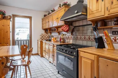 a kitchen with wooden cabinets and a stove top oven at Apartment Tiarè by My Villa Collection in Cortina dʼAmpezzo