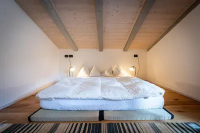 a bedroom with a white bed with two lamps at Cesa Cres in Pera
