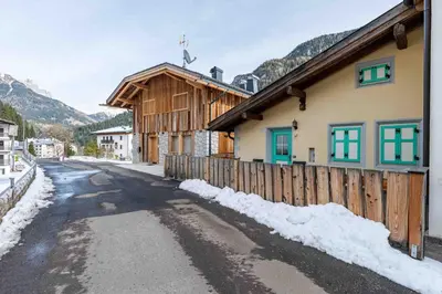 a house with a fence next to a snowy street at Cesa Cres in Pera