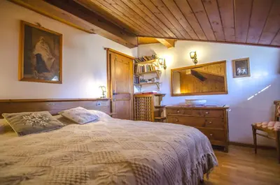 a bedroom with a large bed and a wooden ceiling at La tua mansada in montagna - Comfort e vista in Cortina dʼAmpezzo