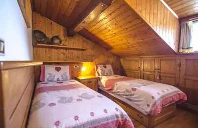 a bedroom with two beds in a wooden cabin at La tua mansada in montagna - Comfort e vista in Cortina dʼAmpezzo