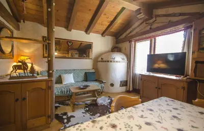 a living room with a couch and a tv at La tua mansada in montagna - Comfort e vista in Cortina dʼAmpezzo