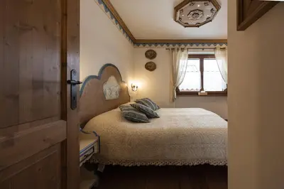 a bedroom with a bed with pillows and a window at Casa Col 2, near ski slopes in Cortina d Ampezzo in Cortina dʼAmpezzo